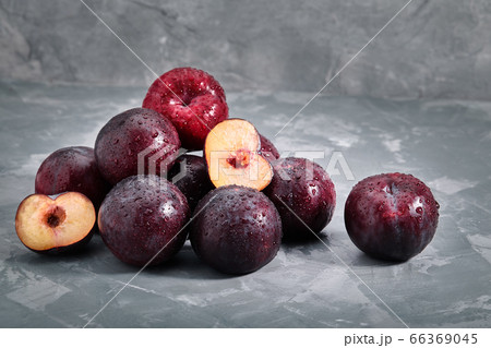 A bunch of fresh plums on a gray background, photo for grocery stores, copy space. A bunch of fresh plums on a gray background, photo for grocery stores, copy space. 66369045