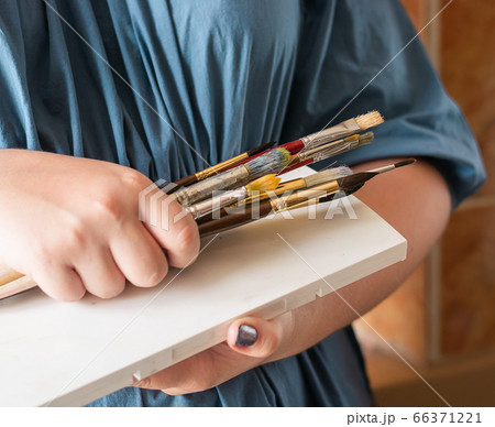 A woman holds brushes in her hands for drawing with watercolors. Hobby art concept. Close-up selective focus. A woman holds brushes in her hands for drawing with watercolors. Hobby art concept. Close-up selective focus. 66371221
