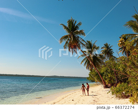 Lovely couple walking at the white sandy beach with palm trees in Onok Island in Balabac Philippines Lovely couple walking at the white sandy beach with palm trees in Onok Island in Balabac Philippines 66372274