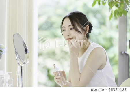 リビングでお肌のお手入れをする若い女性 リビングでお肌のお手入れをする若い女性 66374183