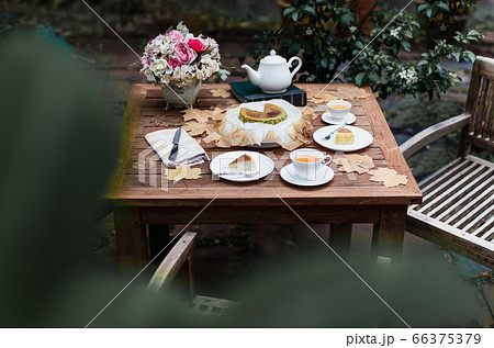 Afternoon tea basque burnt cheesecake and tea cup with teapot on wooden table. Afternoon tea basque burnt cheesecake and tea cup with teapot on wooden table. 66375379