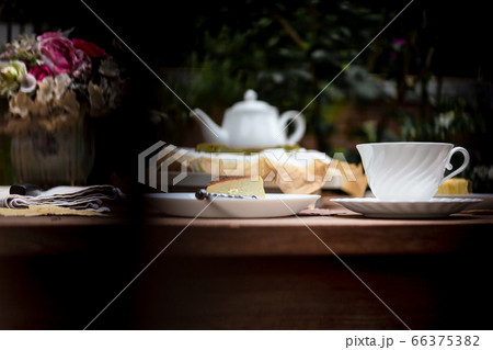 Afternoon tea basque burnt cheesecake and tea cup with teapot on wooden table. Afternoon tea basque burnt cheesecake and tea cup with teapot on wooden table. 66375382