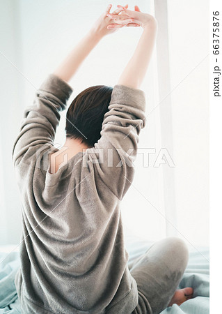 背伸びする寝起きの30代女性 背伸びする寝起きの30代女性 66375876