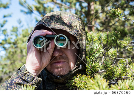 spy or scout looking through binoculars 66376566