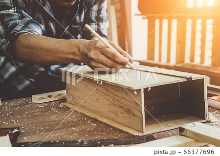 Carpenter working on wood craft at workshop 66377696