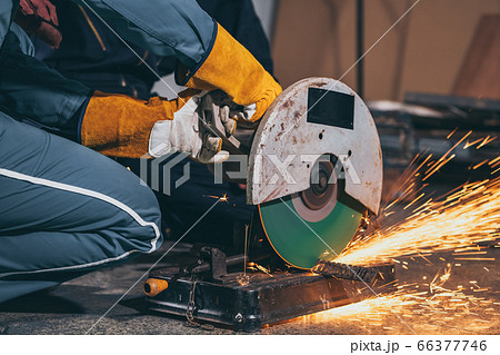 Professional mechanic man is cutting steel metal Professional mechanic man is cutting steel metal 66377746