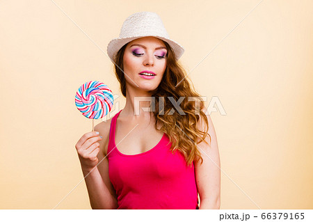 Woman holds colorful lollipop candy in hand 66379165