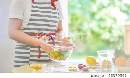 女の子がキッチンでサラダを作っている 料理のイメージ の写真素材
