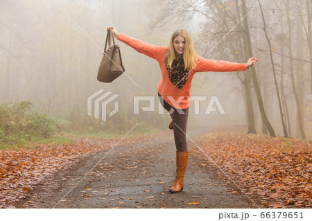 Carefree fashion woman relaxing in autumn park. Carefree fashion woman relaxing in autumn park. 66379651