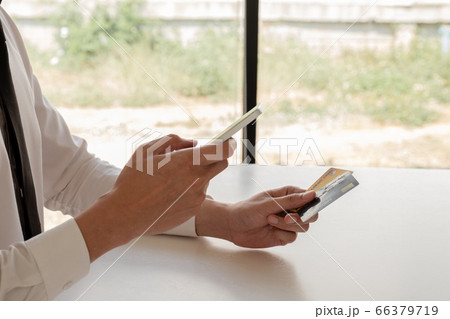 The hands of business people holding credit cards and smartphones for online shopping and paying via the internet The hands of business people holding credit cards and smartphones for online shopping and paying via the internet 66379719