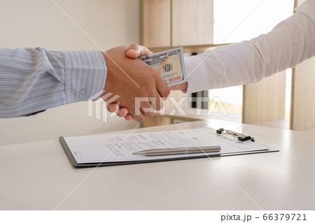 photo of Businessmen shake hands and dollar note, sign a contract to bribe corruption in the company photo of Businessmen shake hands and dollar note, sign a contract to bribe corruption in the company 66379721