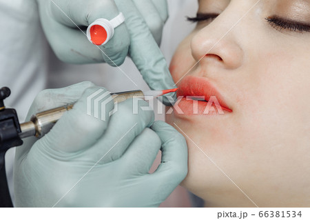 Woman having permanent makeup on lips 66381534