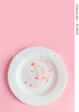 Dirty plate with food leftovers on pink 66384691