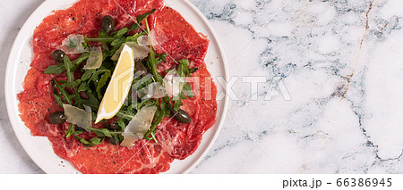 Marbled beef carpaccio with arugula, capers, lemon Marbled beef carpaccio with arugula, capers, lemon 66386945