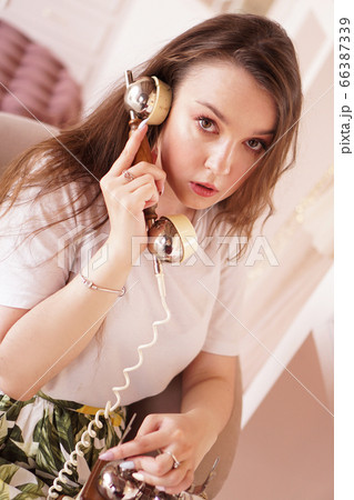 A woman talks on the phone. phone handset in retro style 66387339