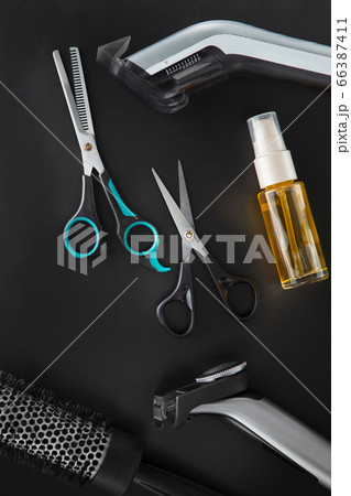 Barber tools for cutting and styling on a black background. 66387411