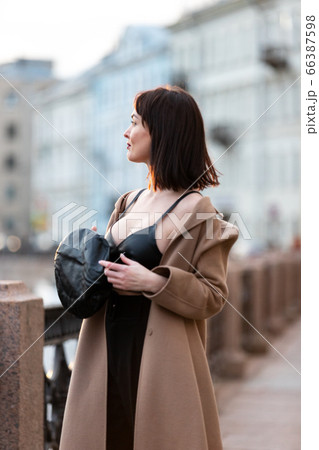 Woman in black pantsuit walks on promenade Woman in black pantsuit walks on promenade 66387598