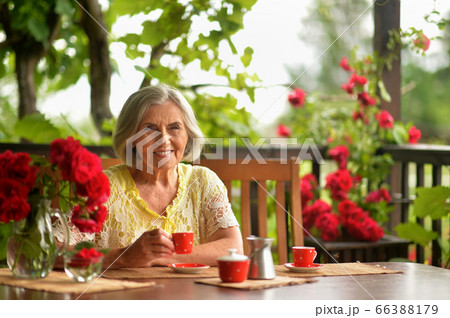 Portrait of happy aged woman drinking coffee Portrait of happy aged woman drinking coffee 66388179