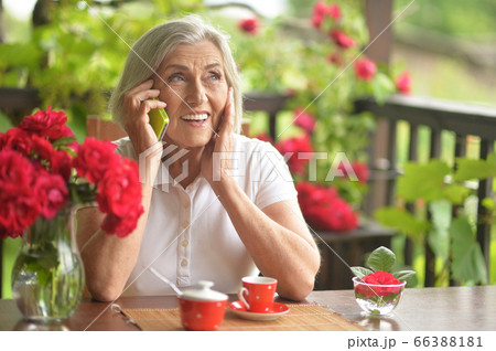 Portrait of a happy aged woman talking on smartphone 66388181