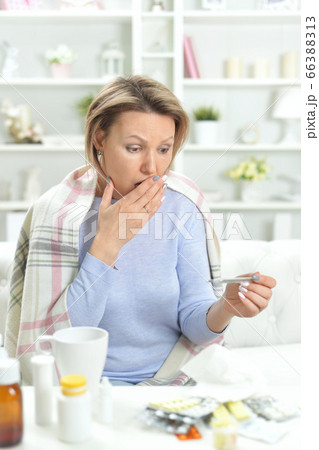 Portrait of beautiful young woman measuring temperature Portrait of beautiful young woman measuring temperature 66388313