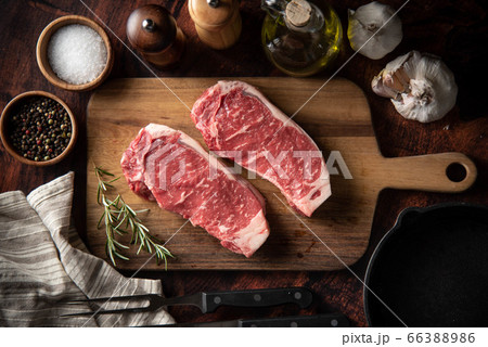 raw strip beef steak meat on wooden cutting board 66388986