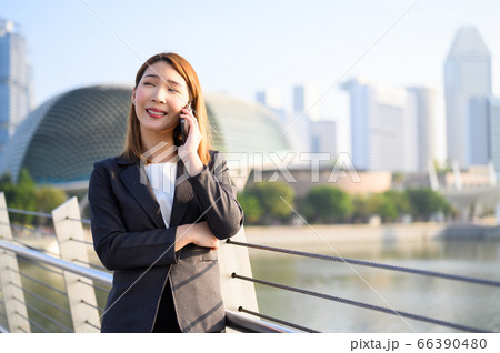 Young Asian business woman talking on phone 66390480