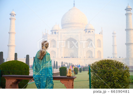 Portrait of young woman in Turquoise blue saree indian traditional dress against Taj Mahal 66390481