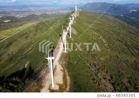 Aerial view of windmills farm for renewable energy production on beautiful blue sky. Wind power 66393105