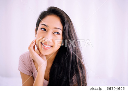 Beautiful young asian woman happy and smiling face while sitting at home 66394696