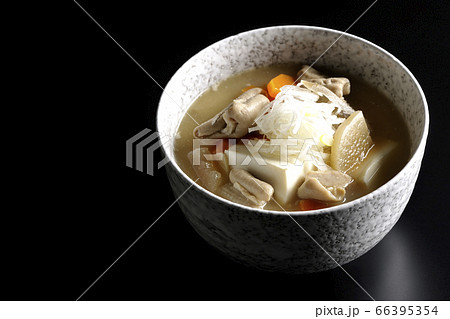 大根、人参、牛蒡、豆腐が入った具だくさんの味噌味もつ煮込み（黒背景） 66395354
