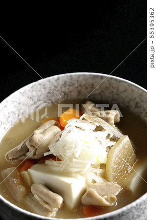 大根、人参、牛蒡、豆腐が入った具だくさんの味噌味もつ煮込み（黒背景） 66395362