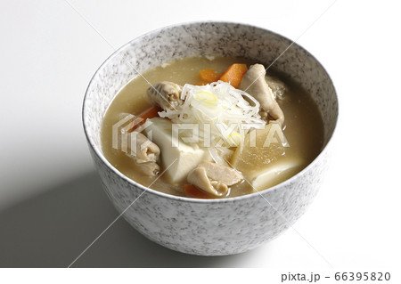 大根、人参、豆腐が入った具だくさんの味噌味もつ煮込み（白背景） 66395820