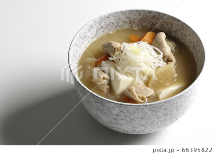 大根、人参、豆腐が入った具だくさんの味噌味もつ煮込み（白背景） 66395822