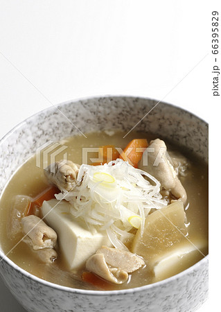 大根、人参、豆腐が入った具だくさんの味噌味もつ煮込み（白背景） 66395829