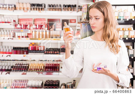 Woman choosing perfume in cosmetics store 66400863