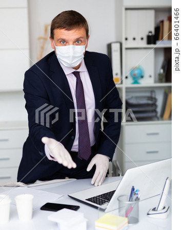 Businessman in mask and gloves welcoming to office 66401466
