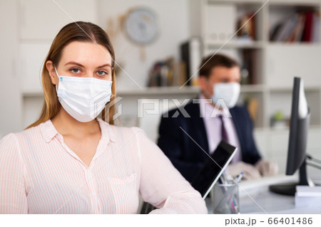 Businesswoman in protective medical mask in office Businesswoman in protective medical mask in office 66401486