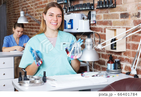 woman nail master in gloves sitting at her workplace woman nail master in gloves sitting at her workplace 66401784