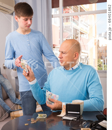 Father giving money to son Father giving money to son 66401862