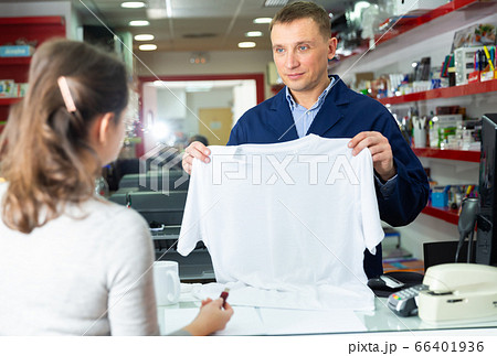 Male administrator offers white t-shirt for drawing picture Male administrator offers white t-shirt for drawing picture 66401936