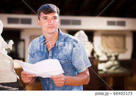 Man with brochure looking at exposition Man with brochure looking at exposition 66402175
