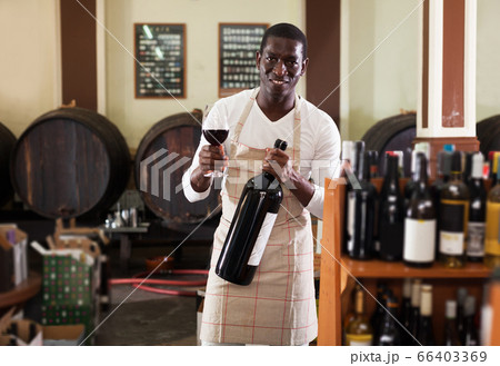 salesman with wineglass and bottle of wine offering to taste product salesman with wineglass and bottle of wine offering to taste product 66403369