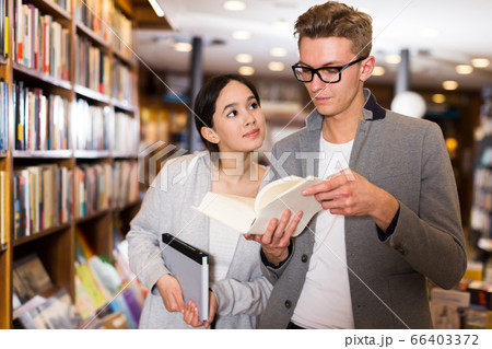 Glad handsome man and girl choosing books Glad handsome man and girl choosing books 66403372