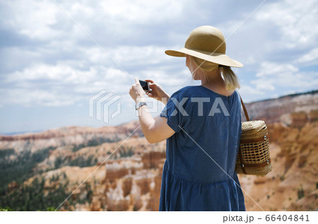USA, Utah, Bryce Canyon, Woman photographing canyon with smart phone 66404841