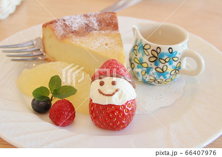かわいいイチゴのサンタクロースが乗ったチーズケーキ 66407976