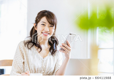 明るい室内でデスクワークをする女性（カメラ目線） 66411988