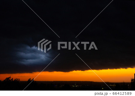 Black thunderclouds at sunset. Bright orange 66412589