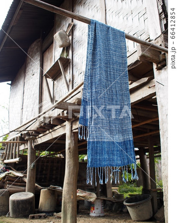 hand crafted indigo cloth hanging in a village with blur vintage retro style rural house cottage blur in background in LUANG PRABANG province, LAOS 66412854