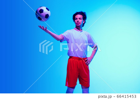 Football or soccer player on gradient background in neon light - motion, action, activity concept 66415453
