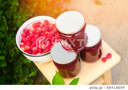 banks with fragrant homemade raspberry jam in the garden. summer harvest. sweet food. food stock for the winter. countryside, outdoor. nature banks with fragrant homemade raspberry jam in the garden. summer harvest. sweet food. food stock for the winter. countryside, outdoor. nature 66418694